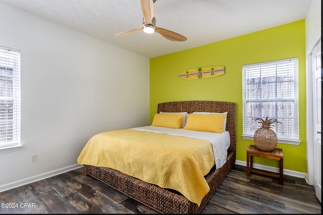 bedroom with ceiling fan, multiple windows, and dark hardwood / wood-style floors