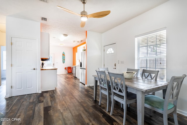 dining area with dark wood-style floors, visible vents, ceiling fan, and baseboards