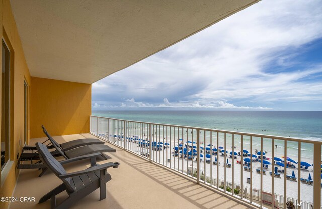 balcony featuring a water view and a beach view