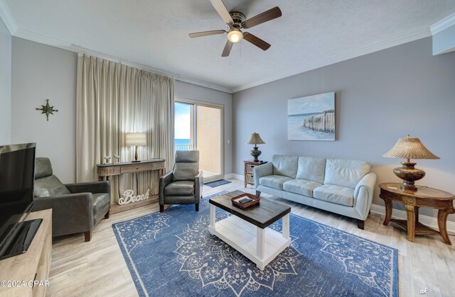 living room featuring ornamental molding, hardwood / wood-style floors, a textured ceiling, and ceiling fan