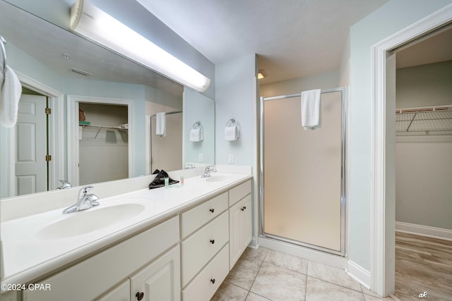 bathroom featuring tile patterned floors, vanity, and an enclosed shower