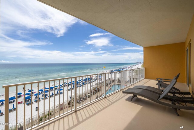 balcony featuring a view of the beach and a water view