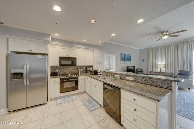 kitchen featuring light stone counters, white cabinetry, black appliances, and kitchen peninsula