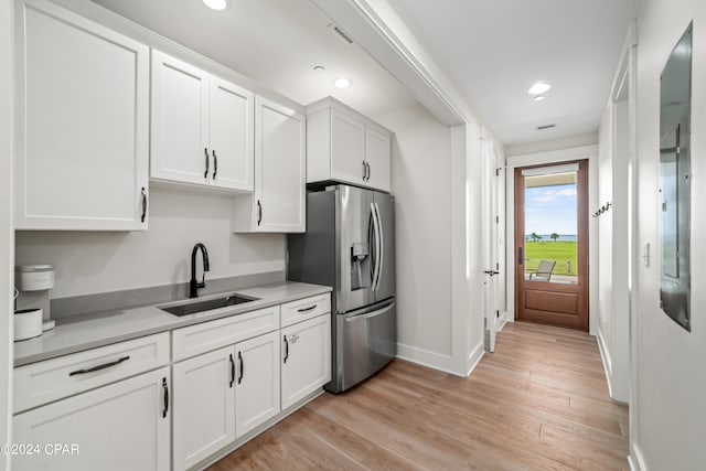 kitchen with white cabinetry, light wood-type flooring, sink, and stainless steel fridge with ice dispenser