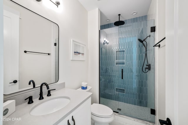 bathroom featuring walk in shower, vanity, and toilet