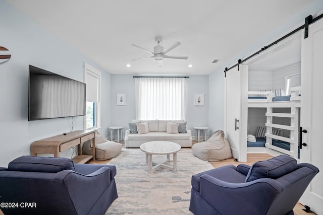 living room with ceiling fan and light hardwood / wood-style flooring