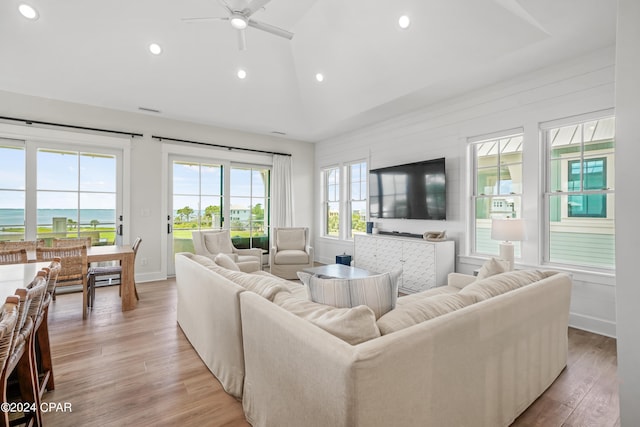 living room with light hardwood / wood-style floors, a water view, and ceiling fan