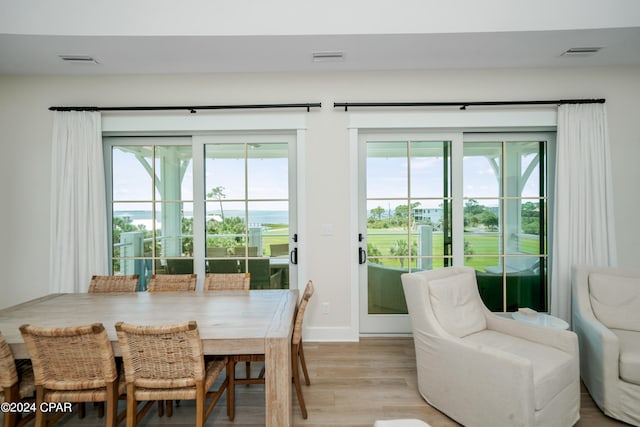 dining area with a wealth of natural light and light hardwood / wood-style flooring