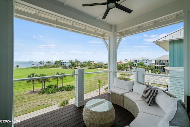 wooden terrace with outdoor lounge area, a water view, and ceiling fan