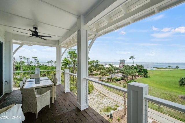 deck featuring a porch, a water view, ceiling fan, and a yard