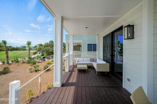 wooden terrace featuring an outdoor living space and covered porch