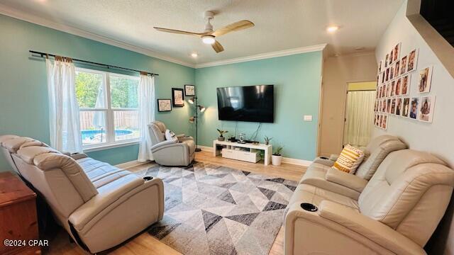 living room with ceiling fan, hardwood / wood-style floors, and crown molding