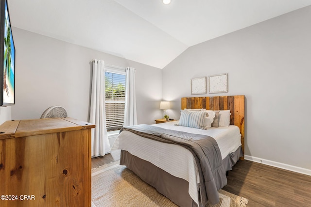 bedroom with lofted ceiling, baseboards, and wood finished floors