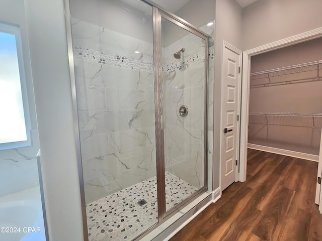 bathroom featuring plenty of natural light, wood-type flooring, and walk in shower