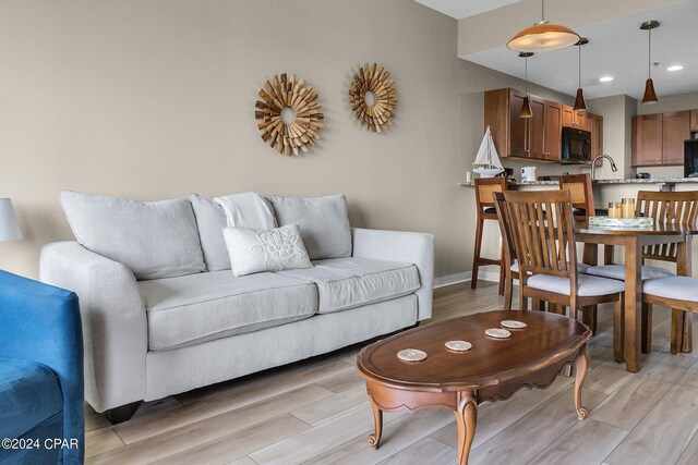 living room with sink and light wood-type flooring