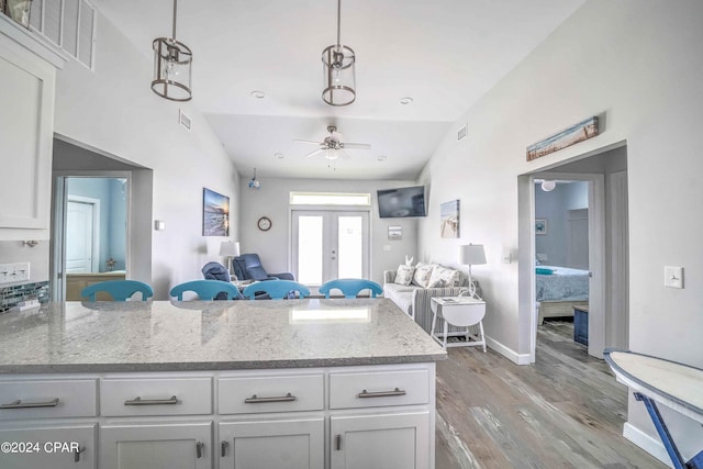 kitchen featuring white cabinetry, ceiling fan, lofted ceiling, and light hardwood / wood-style floors