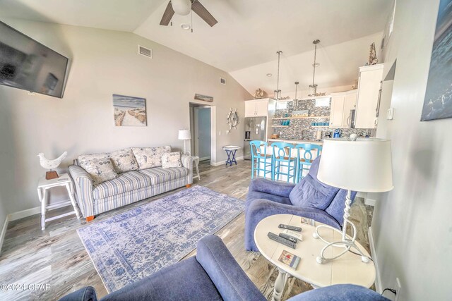 living room with lofted ceiling, light wood-type flooring, and ceiling fan