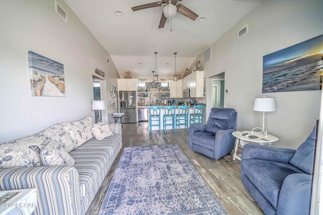 living room with high vaulted ceiling, light hardwood / wood-style flooring, and ceiling fan