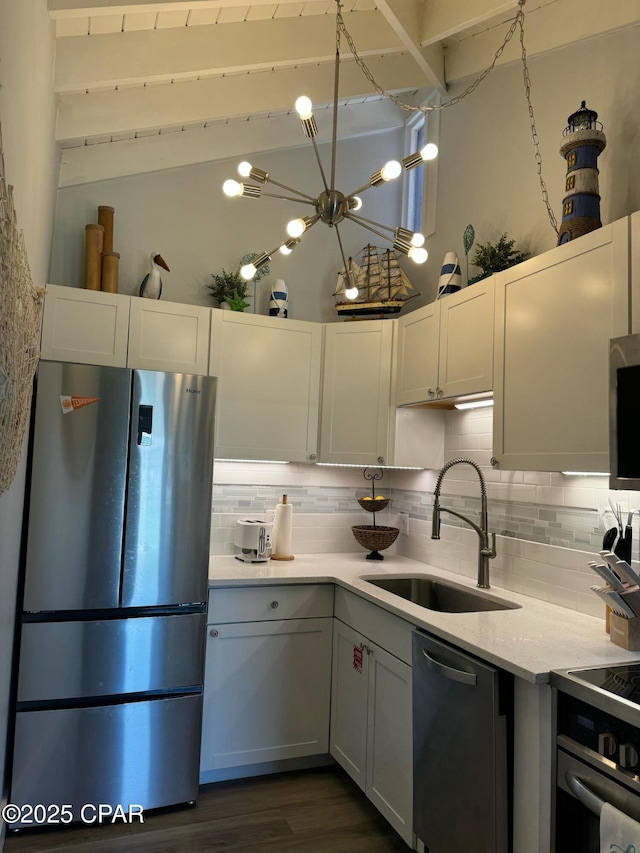 kitchen featuring a sink, light countertops, decorative backsplash, and stainless steel appliances