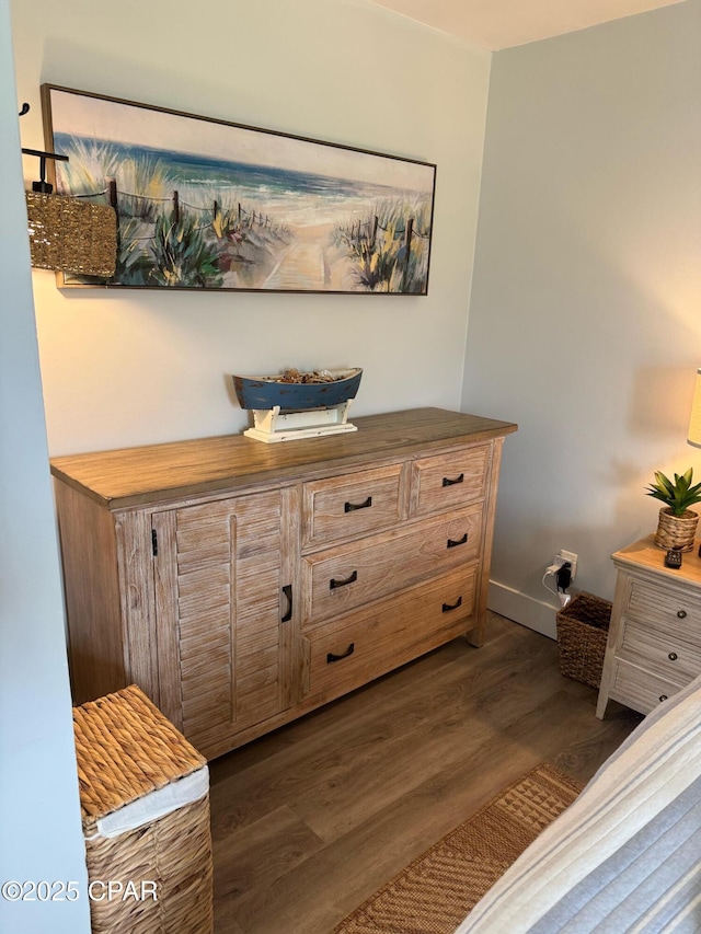 bedroom with baseboards and dark wood-style flooring