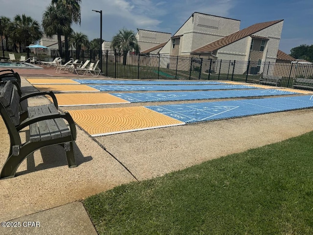 view of property's community featuring shuffleboard and fence