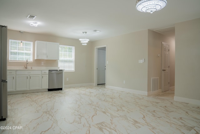 kitchen with pendant lighting, sink, stainless steel appliances, and white cabinets