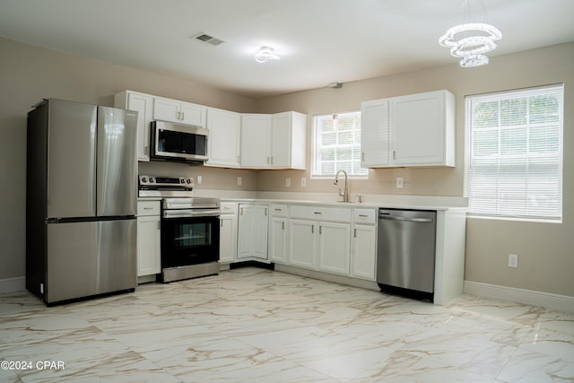 kitchen featuring an inviting chandelier, sink, appliances with stainless steel finishes, and white cabinetry