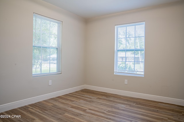 empty room with a healthy amount of sunlight and hardwood / wood-style floors