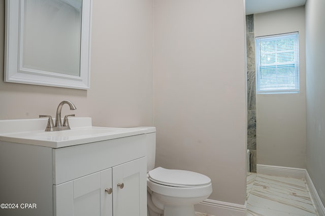 bathroom featuring vanity, toilet, and tiled shower