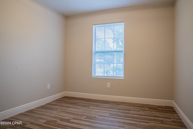 spare room featuring plenty of natural light and dark hardwood / wood-style flooring