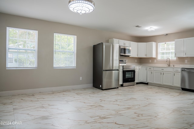 kitchen featuring white cabinets, stainless steel appliances, and sink