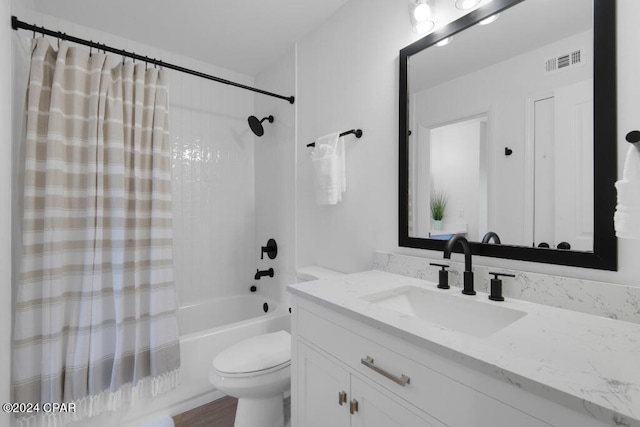 full bathroom with hardwood / wood-style flooring, vanity, shower / bath combo, and toilet