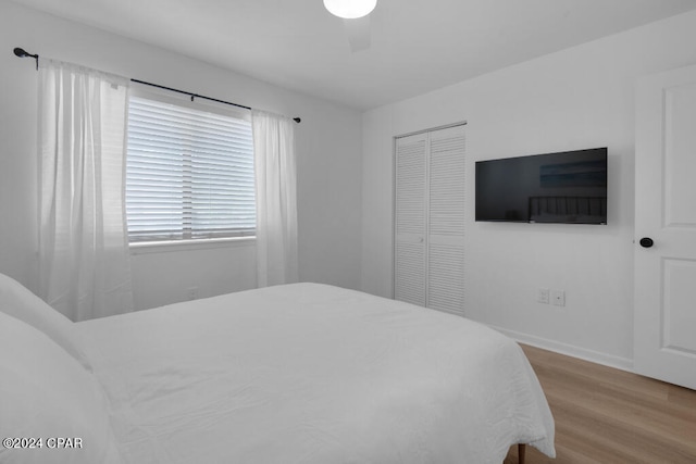 bedroom featuring light hardwood / wood-style floors, a closet, and ceiling fan