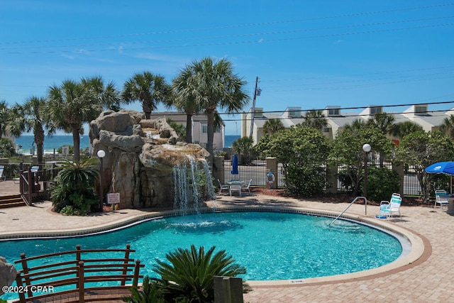 view of swimming pool featuring pool water feature and a patio area