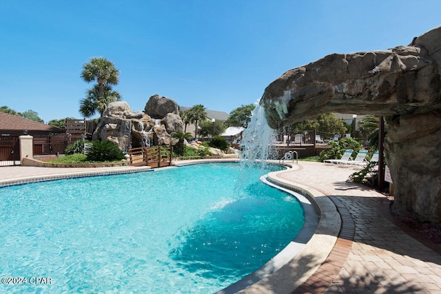 view of swimming pool with pool water feature