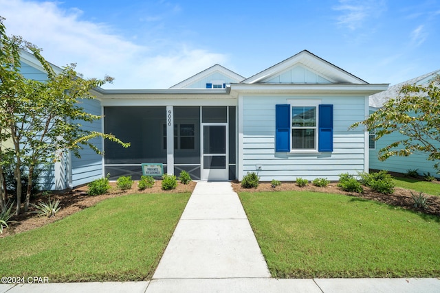 view of front of house with a sunroom and a front yard