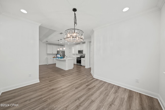 unfurnished living room with crown molding, a notable chandelier, and light hardwood / wood-style floors