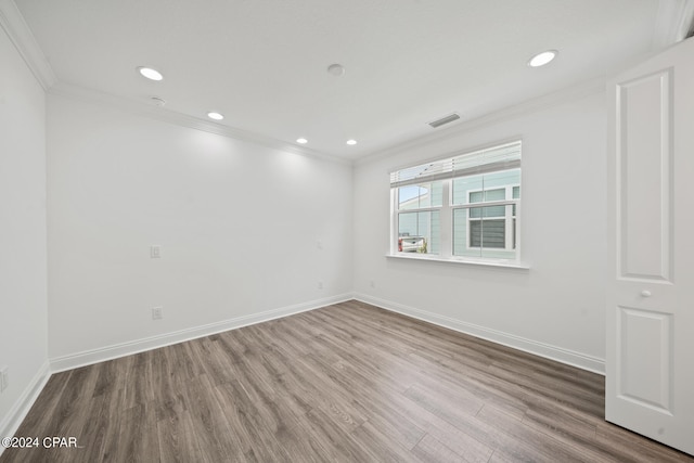 empty room featuring crown molding and hardwood / wood-style floors