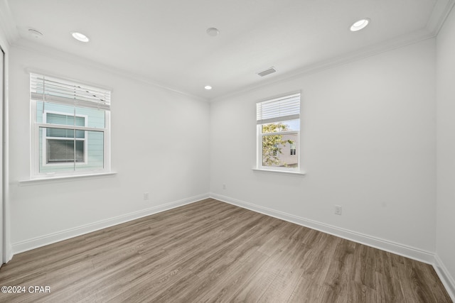 empty room featuring ornamental molding and hardwood / wood-style floors