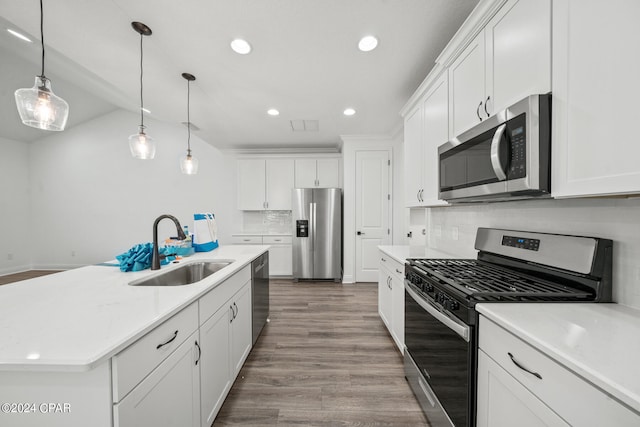 kitchen featuring a kitchen island with sink, stainless steel appliances, hardwood / wood-style floors, decorative backsplash, and sink