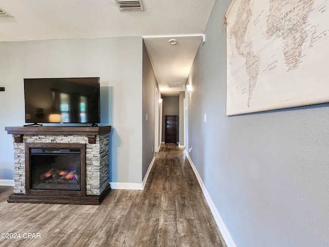 hall with hardwood / wood-style floors and a textured ceiling