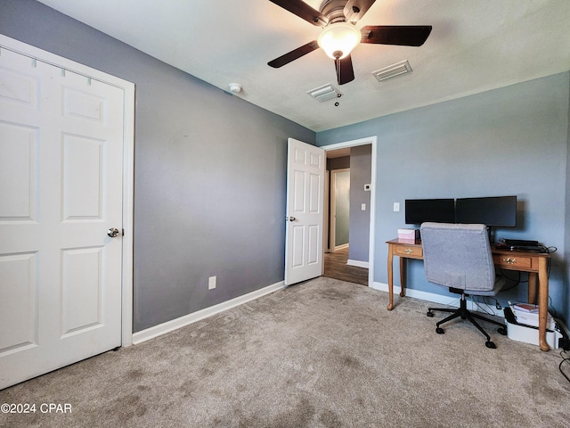 carpeted home office featuring ceiling fan