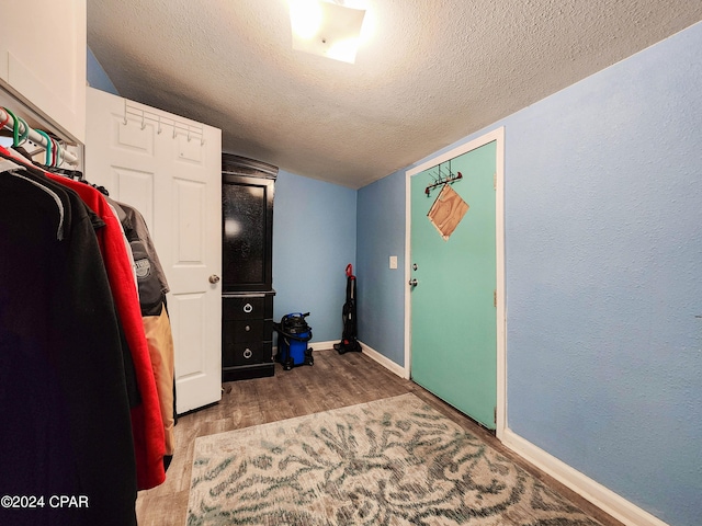 laundry area featuring a textured ceiling and hardwood / wood-style flooring