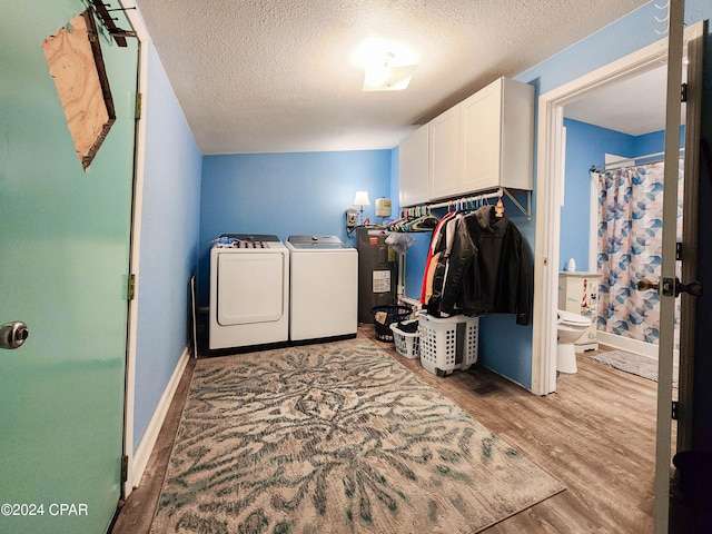 clothes washing area featuring cabinets, light hardwood / wood-style floors, separate washer and dryer, and a textured ceiling