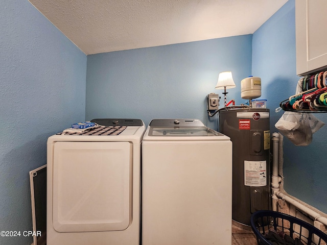 clothes washing area with electric water heater, a textured ceiling, and independent washer and dryer