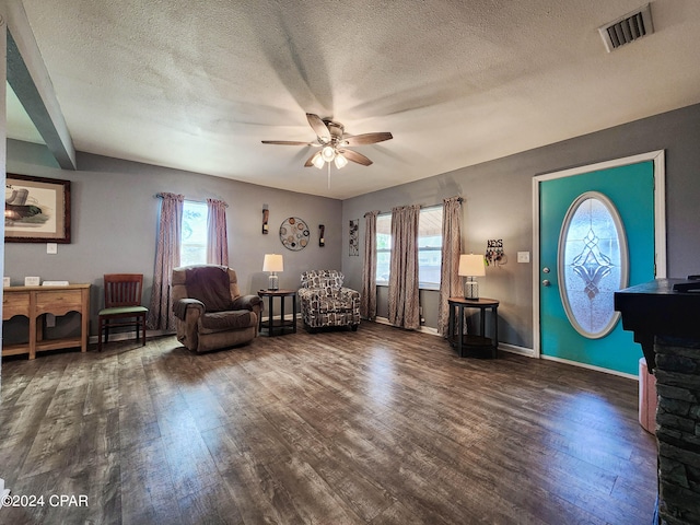 interior space with a textured ceiling, a wealth of natural light, and dark hardwood / wood-style floors