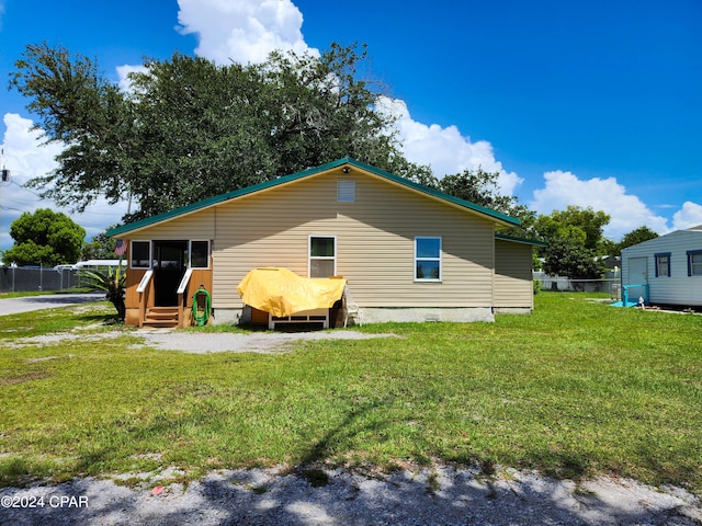 rear view of house featuring a lawn