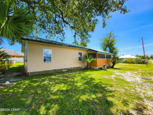 rear view of property featuring a lawn