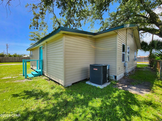 view of home's exterior with central air condition unit and a lawn