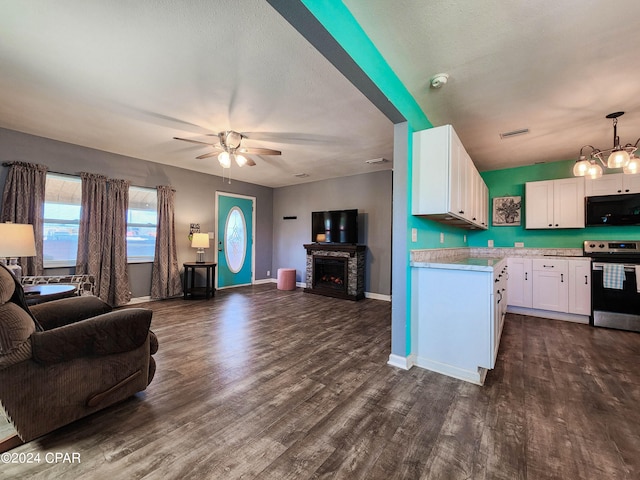 kitchen with white cabinetry, ceiling fan with notable chandelier, stainless steel range, pendant lighting, and dark hardwood / wood-style flooring